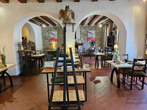 a restaurant with tables and chairs in a room at Logis Hostellerie Du Grand Duc hôtel restaurant in Gincla