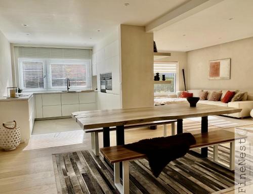 eine Küche und ein Wohnzimmer mit einem Tisch und einem Sofa in der Unterkunft Villa 3 chambres "La luxueuse Ardennes" by FineNest in Chaudfontaine