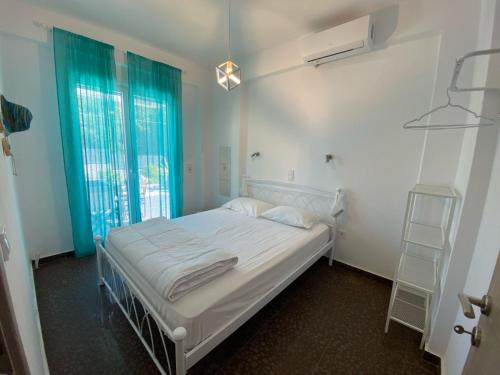 a white bed in a room with a window at SUN KISS HOUSES Sun Kiss Houses B in Áyios Spirídhon