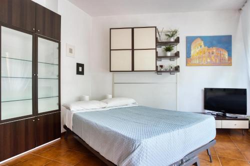 Schlafzimmer mit einem Bett und einem Flachbild-TV in der Unterkunft Domus Parnaso - Eur in Rom