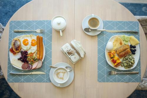 a table with two plates of breakfast foods and a cup of coffee at Kenari Hotel in Tbilisi City