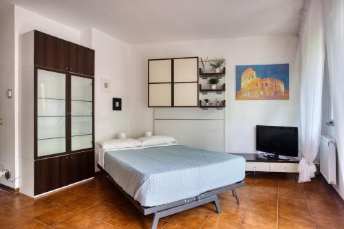 a bedroom with a bed and a flat screen tv at Domus Parnaso - Eur in Rome