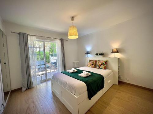 Un dormitorio con una cama y una ventana grande. en Vilamoura Eden Villa With Pool by Homing, en Vilamoura
