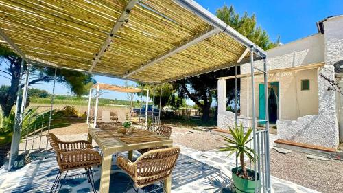 a wooden table and chairs under a wooden pergola at Unique Cycladic Detached House - Private Garden - Helena in Análipsis