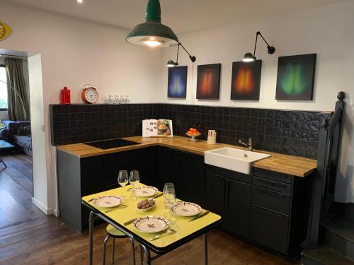 eine Küche mit einem Tisch und einem Waschbecken in der Unterkunft Maison Saint Denis stade de France in Saint-Denis