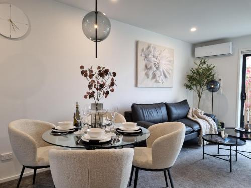 a living room with a table and chairs and a couch at Cloud Nine Elegant Escape Awaits in Christchurch