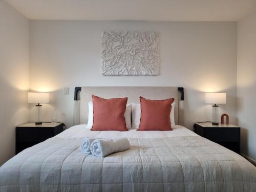 a bedroom with a large bed with red pillows at Cloud Nine Elegant Escape Awaits in Christchurch