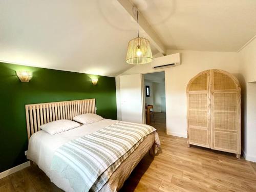 una camera da letto con un letto con una parete verde di La Villa Gioia avec piscine ! ad Afa
