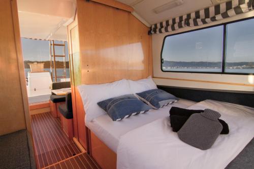 una cama en la parte trasera de un barco en Knysna Houseboats, en Knysna