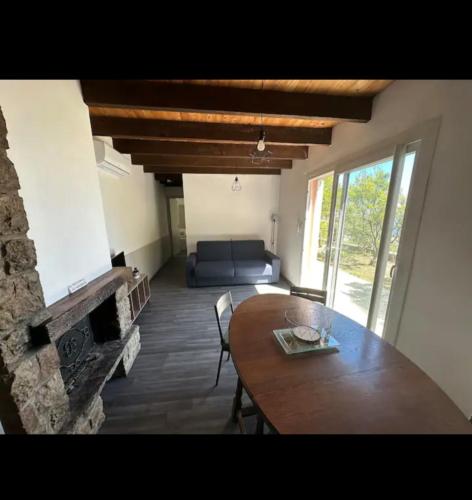 - un salon avec une table en bois et une cheminée dans l'établissement 10 min de Monaco petite maison avec jardin vue mer et rocher de Monaco, à La Turbie