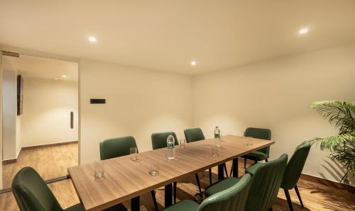 una sala de conferencias con una mesa larga y sillas verdes en Treebo Premium Vapr Ashok Nagar, en Chennai