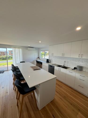 a kitchen with white cabinets and a white counter top at Eden Explorer - Beach - Bike - Hike - Fish in Eden