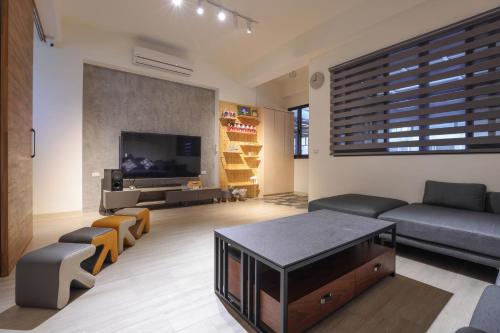 uma sala de estar com um sofá e uma televisão em Peng Together B&B em Magong