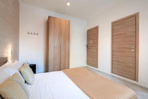 a bedroom with a white bed and wooden doors at Casa Vacanze Carolina 348 in Naples
