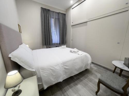 a small room with a white bed and a chair at Lucca Mira in Lucca