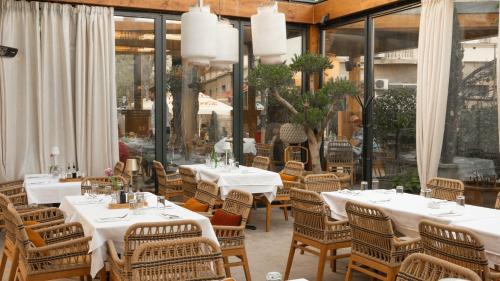 a restaurant with white tables and chairs and windows at Luxury Rooms Skadarlija in Belgrade