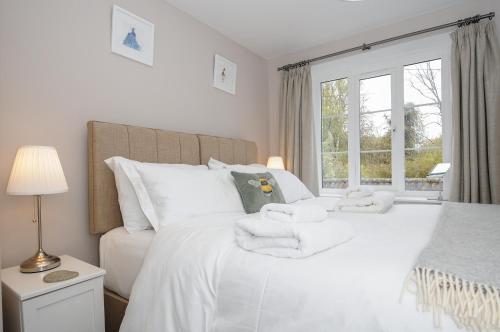 a bedroom with a white bed with towels on it at Hobbs Cottage in Okehampton