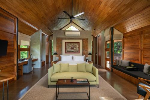 a living room with a green couch and a bed at Taru Villas Maia - Habarana in Habarana