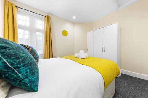 a bedroom with a bed and a yellow and white cabinet at Stylish & Modern 2-Bedroom London Hideaway - King Bed- Sleeps 6 - Parking Available - Instant Book - 20 Percent Off Long Stays! in Barnet