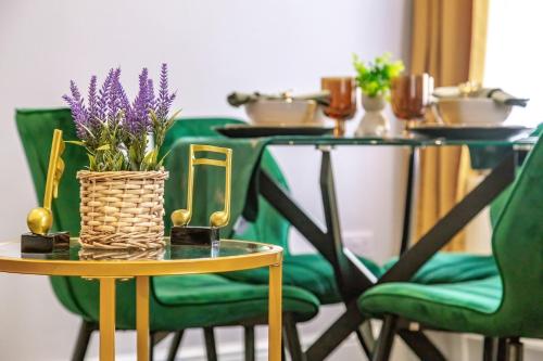 a table with a vase of purple flowers on it at Stylish & Modern 2-Bedroom London Hideaway - King Bed- Sleeps 6 - Parking Available - Instant Book - 20 Percent Off Long Stays! in Barnet