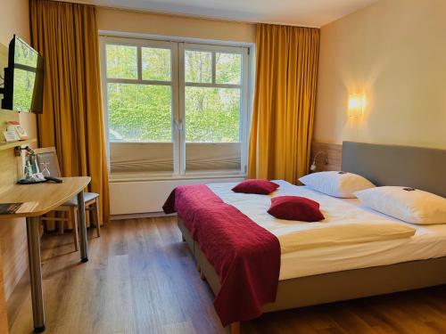 a bedroom with a large bed and a window at Haags Hotel Niedersachsenhof in Verden