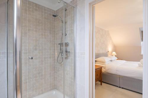 a bathroom with a shower and a tub and a bed at Large detached Cambridgeshire Countryside Home in Wilburton