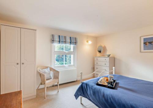 una camera con un letto e una sedia e una finestra di Willow Cottage - Corpusty a Briston