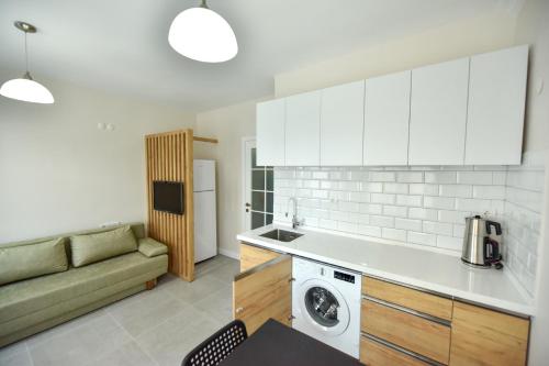 a kitchen with a couch and a washing machine in it at Kordon YALI Suites in Fethiye