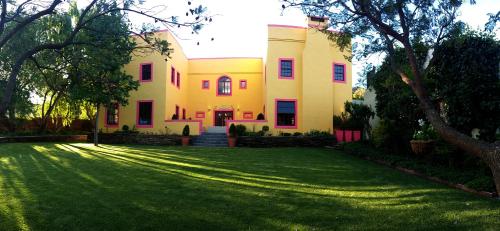 a large house with a green lawn in front of it at Villa Limonicella in Barrydale