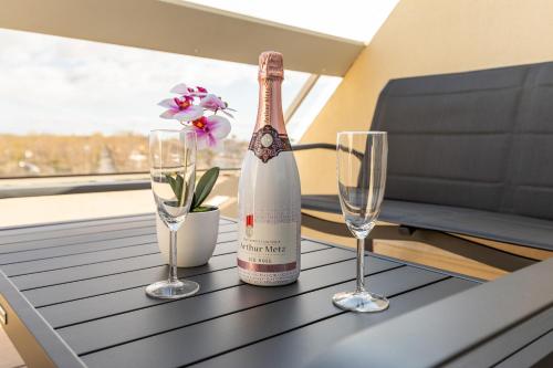 une bouteille de vin et deux verres sur une table dans l'établissement Héliopolis Naturist Luxury, au Cap d'Agde