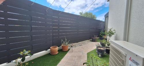 a privacy fence with potted plants on a patio at Apartman Barry in Primošten