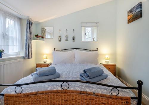 una camera da letto con un letto con due asciugamani blu sopra di Swallows Nest - Briston a Briston