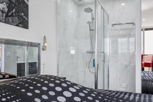 a bathroom with a shower with a glass door at Héliopolis Naturist Luxury in Cap d'Agde