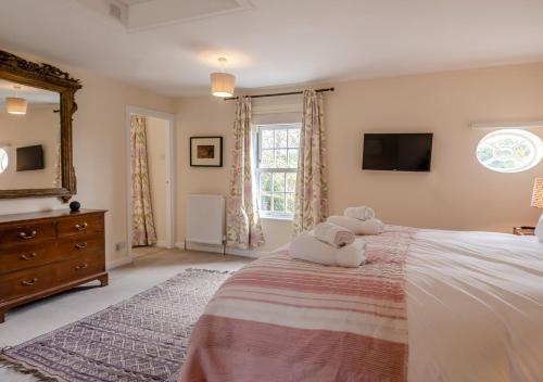a bedroom with a bed with a teddy bear on it at Valley House in Cley next the Sea