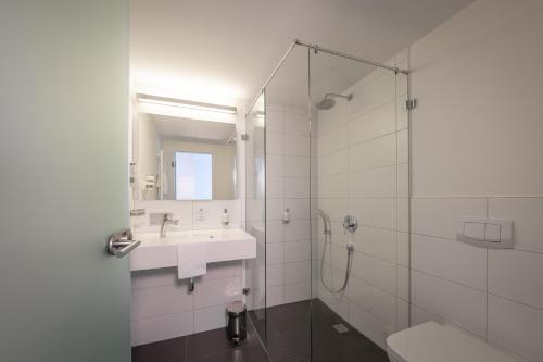 a white bathroom with a sink and a shower at Gästehaus am Schloss in Schwetzingen