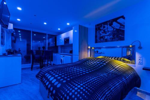 a bedroom with a large bed with blue lighting at Héliopolis Naturist Luxury in Cap d'Agde