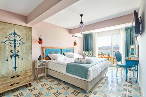 a bedroom with a large bed and a large window at Fİ Light Solto Boutique Beach Hotel in Selimiye