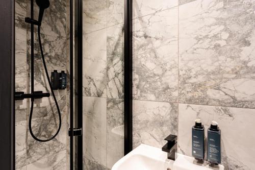 a bathroom with a shower and a sink with two soap bottles at The House on Warwick in London