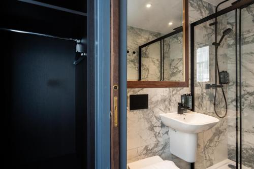 uma casa de banho com um lavatório e um chuveiro em The House on Warwick em Londres