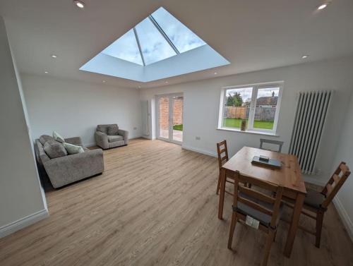 ein Wohnzimmer mit einem Tisch und einem Sofa in der Unterkunft Clovelly Rise in Lowestoft