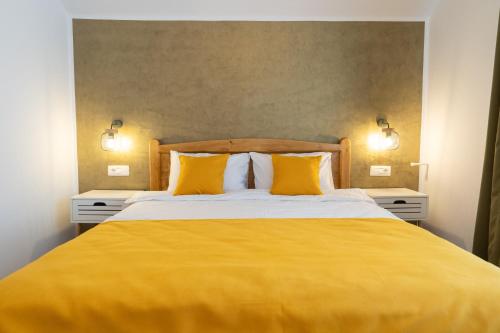 a bedroom with a yellow bed with two yellow pillows at Pensiunea MATRIOSKA in Jurilovca