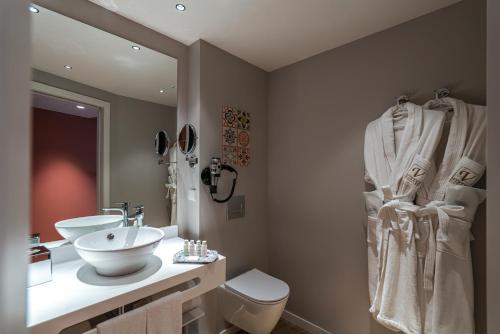 a bathroom with a sink and a toilet and a mirror at Vincci Bonjardim in Porto