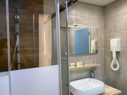 a bathroom with a sink and a mirror at Hotel Garni Montaldi in Locarno