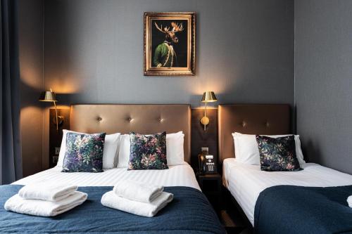 a bedroom with two beds with towels on them at The House on Warwick in London