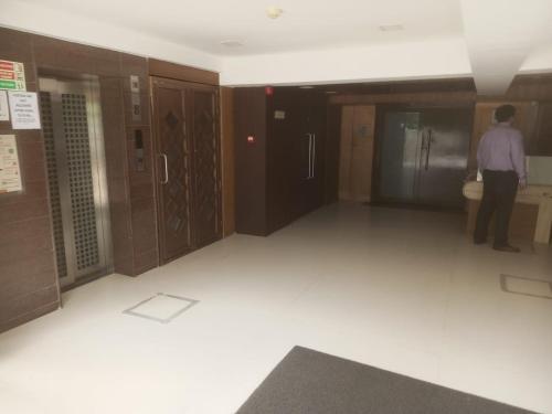 a man standing in a room with a toilet at Hotel signature in Ahmedabad