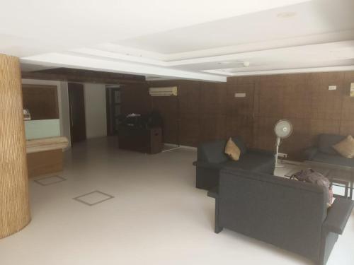 een woonkamer met een bank en een tafel bij Hotel signature in Ahmedabad
