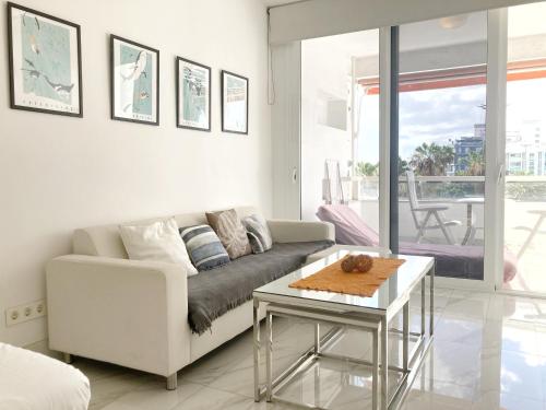 Sala de estar blanca con sofá y mesa en Santa Catalina Beach Flat by Canary365, en Las Palmas de Gran Canaria