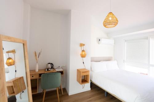 1 dormitorio con cama, escritorio y silla en Hostal Boutique La Malagueña - Only Adults en Estepona