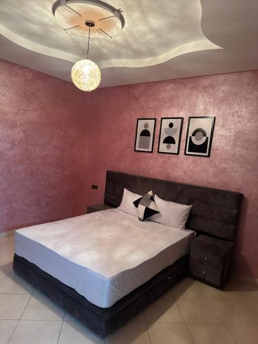 - une chambre avec un grand lit et un mur rose dans l'établissement Luxury Modern Apartment, à Béni Mellal