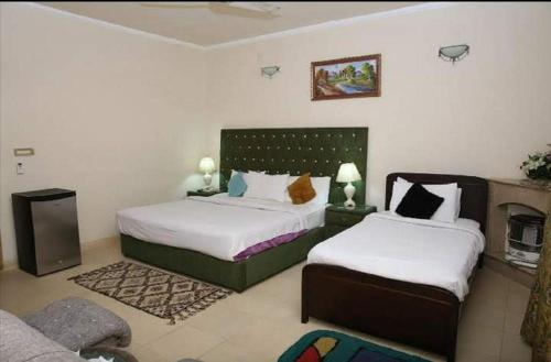 a bedroom with two beds and a couch at Islamabad Lodges in Islamabad
